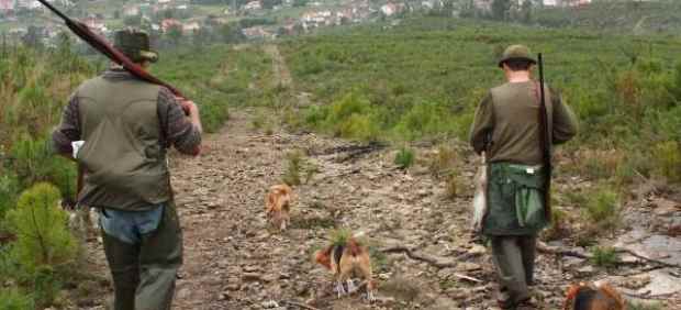 Cazadores con sus armas y sus perros