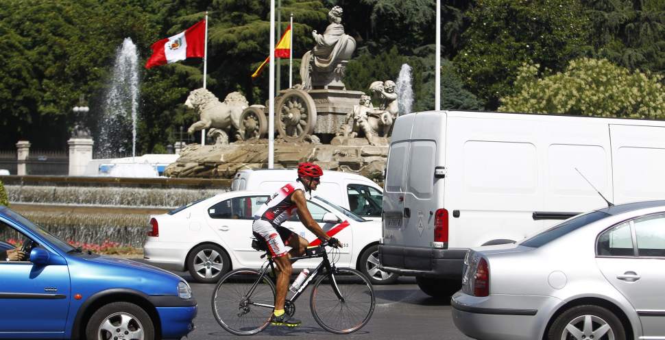 Aficionado a la bicicleta, circulando entre coches en la glorieta de Cibeles de Madrid