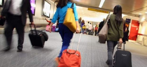 Pasajeros con maleta en aeropuerto 