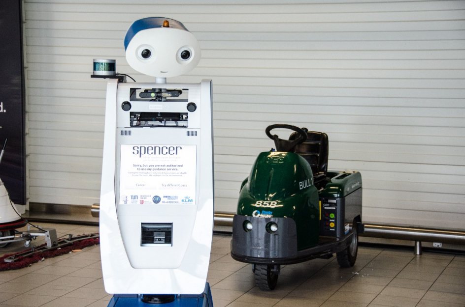 El robot Spencer junto a una máquina limpia suelos