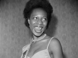 Raphael Albert - (unidentified) Miss West Indies in Great Britain contestant posing at Blythe Road, Hammersmith, London, 1970s. From the portfolio 'Black Beauty Pageants'.