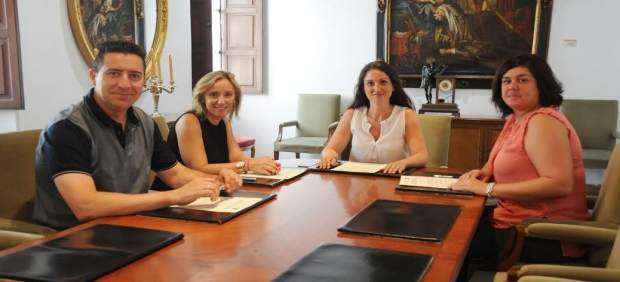 Gómez (centro) tras la firma del acuerdo