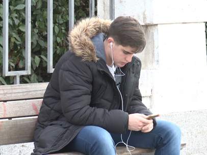 Un joven consulta su teléfono móvil