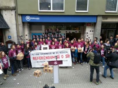 Un grupo de jóvenes miembros de Arran ante la sede del PP en Barcelona.