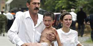 Un niño es rescatado de la escuela de Beslán durante el ataque.