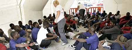 Varios de los 105 inmigrantes indocumentados que han llegado hoy en un cayuco al puerto tinerfeño de Los Cristianos. Varios de los 105 inmigrantes indocumentados que han llegado hoy en un cayuco al puerto tinerfeño de Los Cristianos.