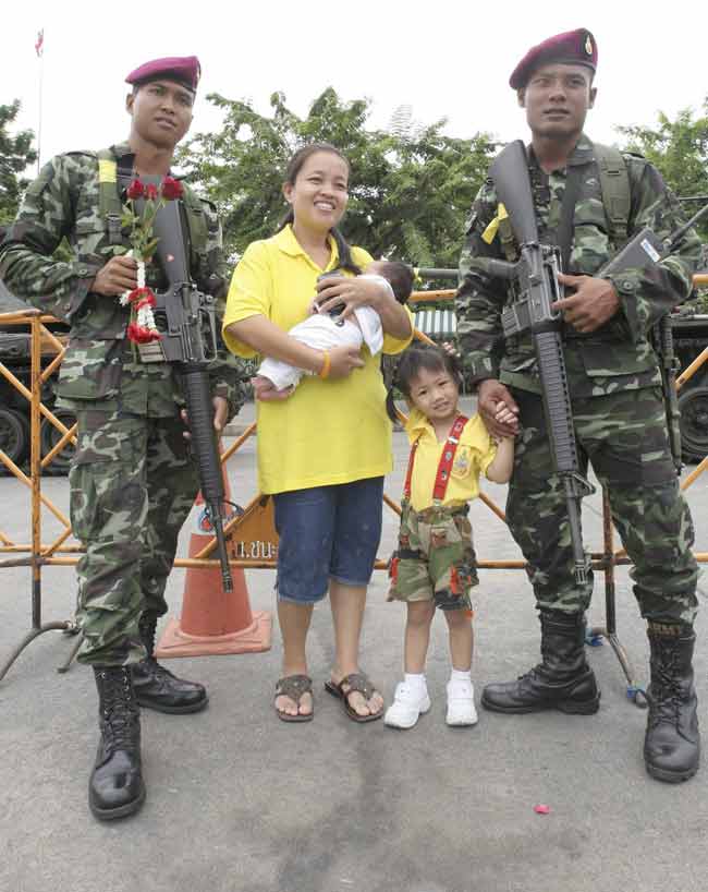 Una familia posa con soldados tailandeses. Una familia posa con soldados tailandeses.