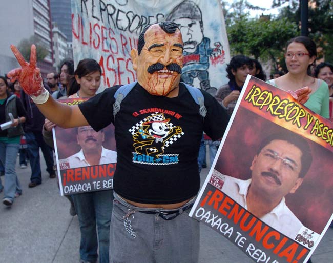 Un manifestante disfrazado de Fox porta un cartel contra el gobernador de Oaxaca. Un manifestante disfrazado de Fox porta un cartel contra el gobernador de Oaxaca.