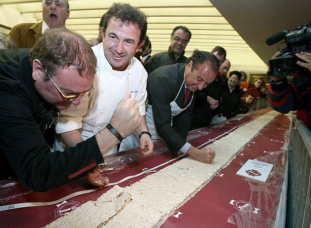 El cocinero Martín Berasategui (en el centro), junto a otros miembros de la organización, ayuda a romper la tableta de turrón El cocinero Martín Berasategui (en el centro), junto a otros miembros de la organización, ayuda a romper la tableta de turrón