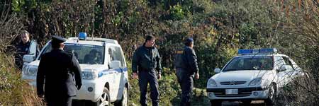 Unos policías examinan el camino rural donde se han encontrado los cadáveres de cinco cazadores. Unos policías examinan el camino rural donde se han encontrado los cadáveres de cinco cazadores.
