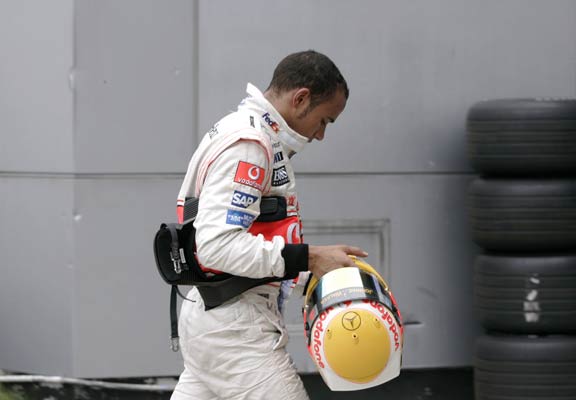 Lweis Hamilton se encamina al 'pit lane' después de sufrir un percance con su coche. Lweis Hamilton se encamina al 'pit lane' después de sufrir un percance con su coche.