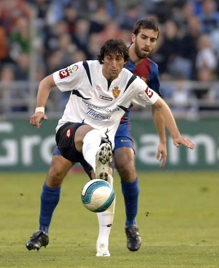 Diego Milito protege el balón ante el acoso de Oleguer. Diego Milito protege el balón ante el acoso de Oleguer.