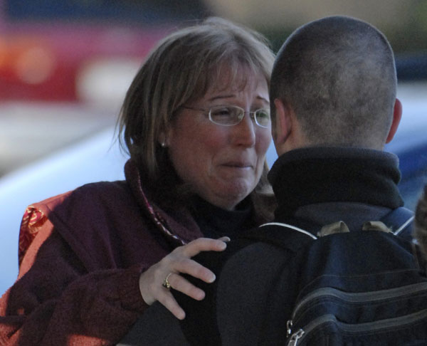 Una madre abraza a un amigo de su hijo, que logró sobrevivir. Una madre abraza a un amigo de su hijo, que logró sobrevivir.