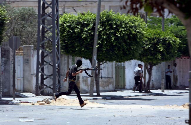 Un miembro del grupo Fatah corre para protegerse durante enfrentamientos contra militantes de Hamas en Gaza Un miembro del grupo Fatah corre para protegerse durante enfrentamientos contra militantes de Hamas en Gaza