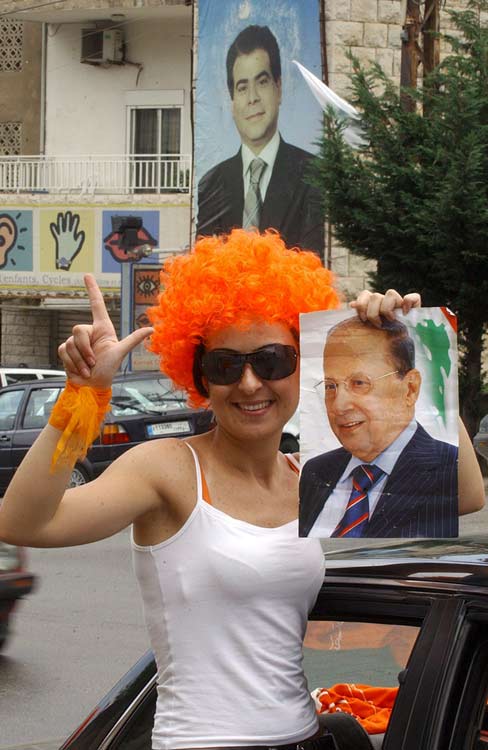 Una mujer libanesa, partidaria del candidato del general opositor Michel Aoun, posa con un cartel de Aoun, frente a un cartel del ministro asesinado Pierre Gemayel Una mujer libanesa, partidaria del candidato del general opositor Michel Aoun, posa con un cartel de Aoun, frente a un cartel del ministro asesinado Pierre Gemayel