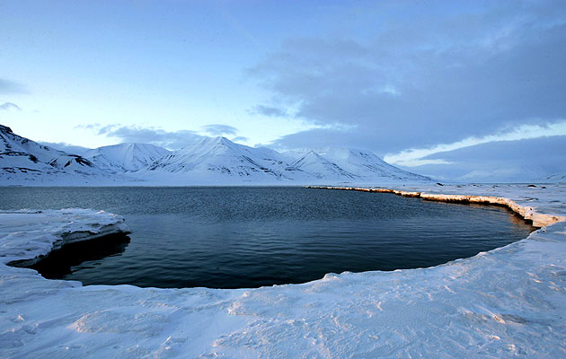La luz del sol ilumina la medianoche en un fiordo cerca del pueblo noruego de Longyearbyen La luz del sol ilumina la medianoche en un fiordo cerca del pueblo noruego de Longyearbyen