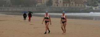 Dos bañistas en la playa San Lorenzo, en Gijón Dos bañistas en la playa San Lorenzo, en Gijón