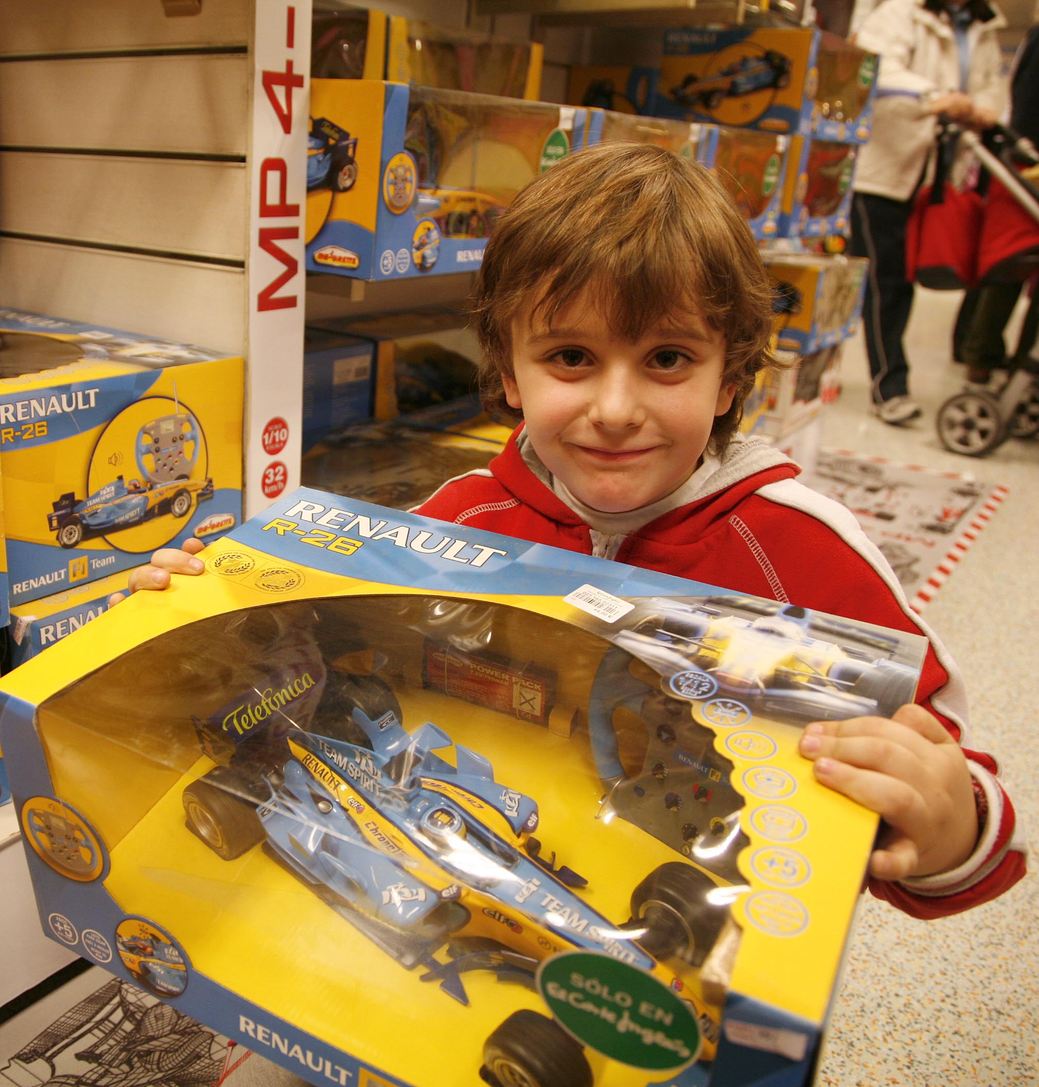 Un niño sostiene en sus manos el coche teledirigido de Fernando Alonso Un niño sostiene en sus manos el coche teledirigido de Fernando Alonso