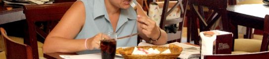 Una mujer come en un restaurante. Una mujer come en un restaurante.