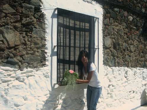 Una mujer de El Ronquillo recoge las flores que han dejado en su ventana. Una mujer de El Ronquillo recoge las flores que han dejado en su ventana.