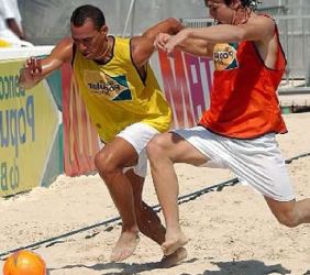 Dos jóvenes disputando un partido de fútbol playa Dos jóvenes disputando un partido de fútbol playa