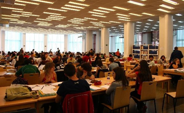 Estudiantes en una biblioteca Estudiantes en una biblioteca