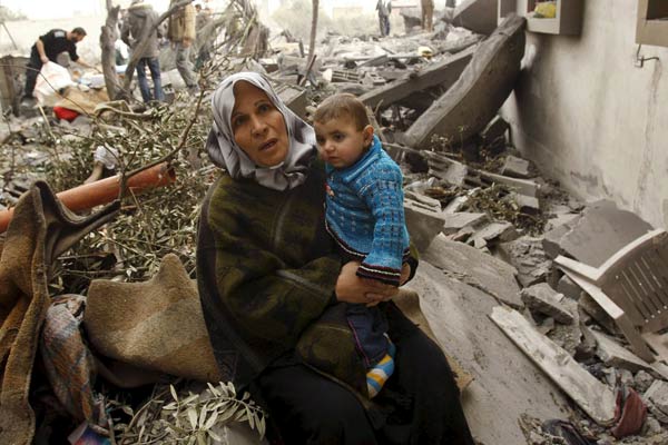 Una mujer palestina, con un niño, sentados sobre las ruinas de su casa Una mujer palestina, con un niño, sentados sobre las ruinas de su casa