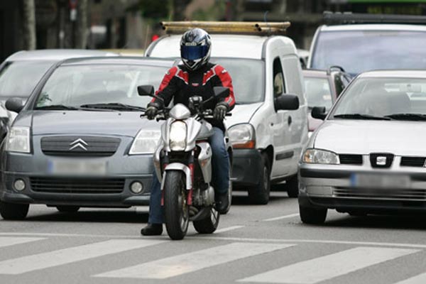 Una moto, entre dos coches. Una moto, entre dos coches.