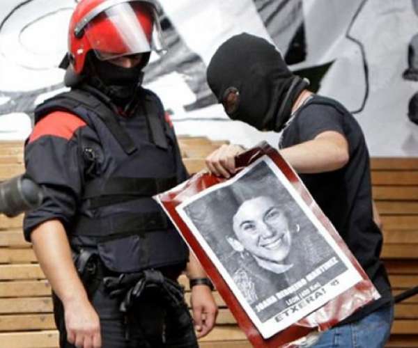 Dos agentes de la Ertzaintza retiran la foto de una presa de ETA. Dos agentes de la Ertzaintza retiran la foto de una presa de ETA.