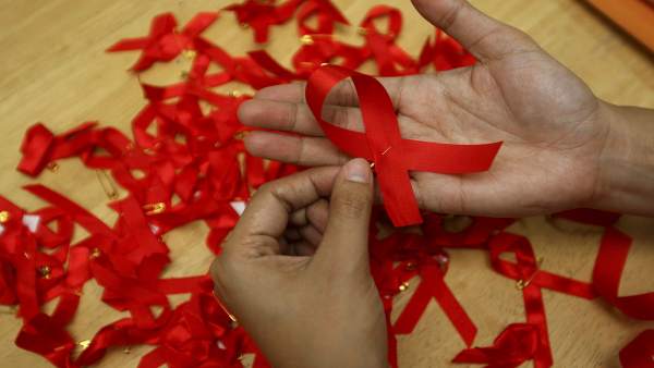 Una joven prepara lazos rojos Una joven prepara lazos rojos