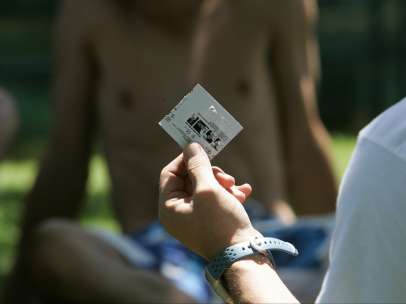 Un joven sostiene un preservativo