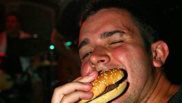 Joven comiendo una hamburguesa Joven comiendo una hamburguesa