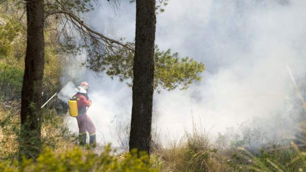 Un bombero apaga el fuego Un bombero apaga el fuego