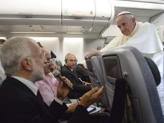 El papa Francisco (dcha) escucha la pregunta de uno de los periodistas durante una rueda de prensa dada a bordo del avión que le traslada a Italia tras abandonar Río de Janeiro (Brasil).