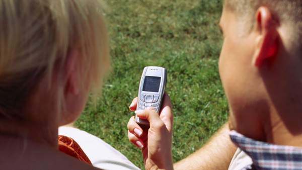 Dos personas envían un SMS con el móvil. Dos personas envían un SMS con el móvil.