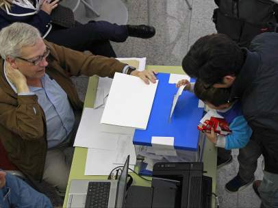 Un niño introduce el voto de su padre en una urna en las elecciones al Parlamento Europeo celebradas en Cataluña.