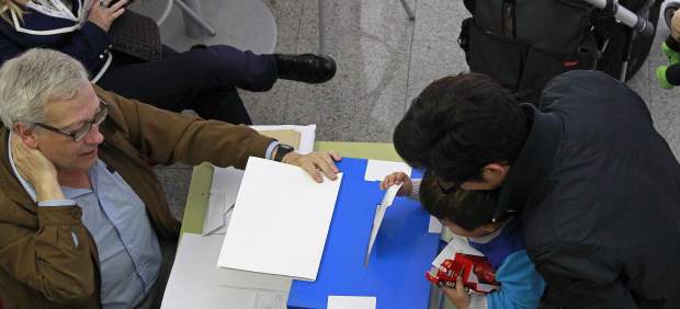 Un niño introduce el voto de su padre en una urna en las elecciones al Parlamento Europeo celebradas en Cataluña.