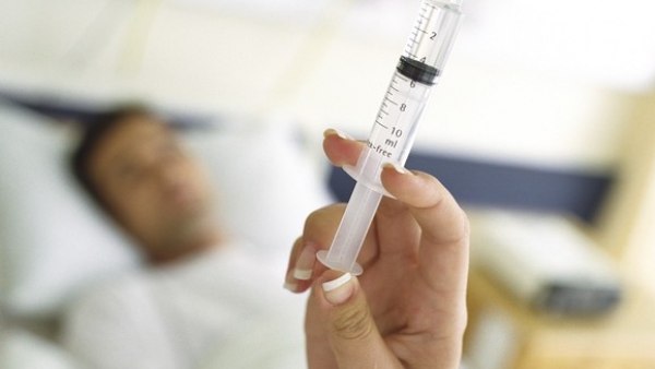 Un paciente espera una inyección en un hospital Un paciente espera una inyección en un hospital