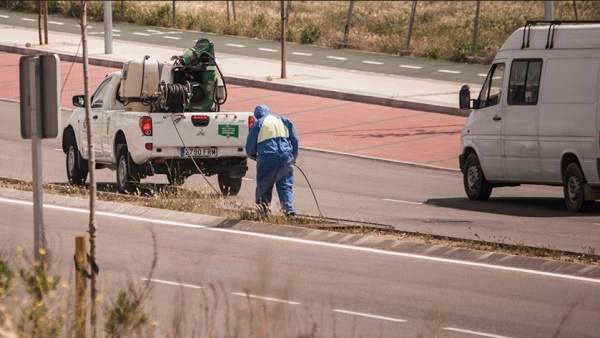 Operarios fumigando una calzada Operarios fumigando una calzada