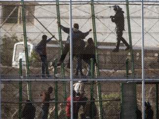 Ciudadanos subsaharianos en la valla que separa Melilla de Marruecos