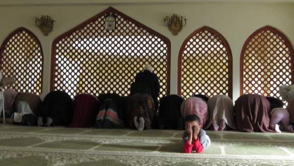 Niño junto a mujeres rezando en una mezquita Niño junto a mujeres rezando en una mezquita