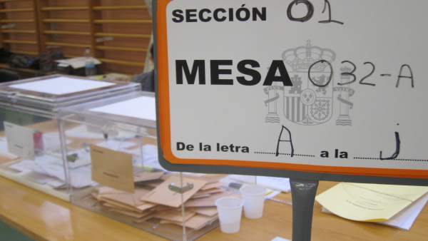 Cartel de una mesa electoral con las urnas al fondo Cartel de una mesa electoral con las urnas al fondo