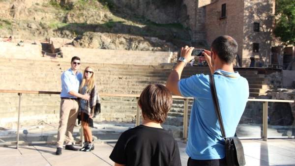 Un turista haciendo una fotografía a otros turistas Un turista haciendo una fotografía a otros turistas