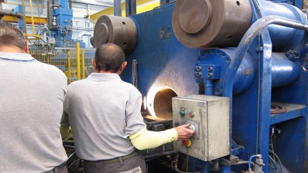 Dos operarios manipulando una máquina en una fábrica. Dos operarios manipulando una máquina en una fábrica.