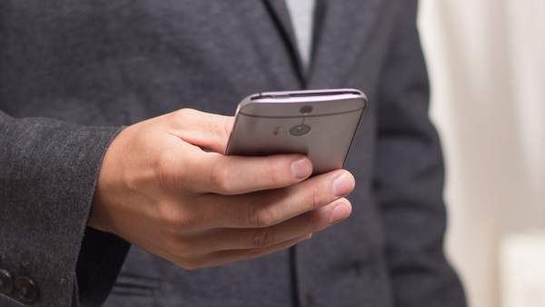 Hombre usando un teléfono móvil Hombre usando un teléfono móvil