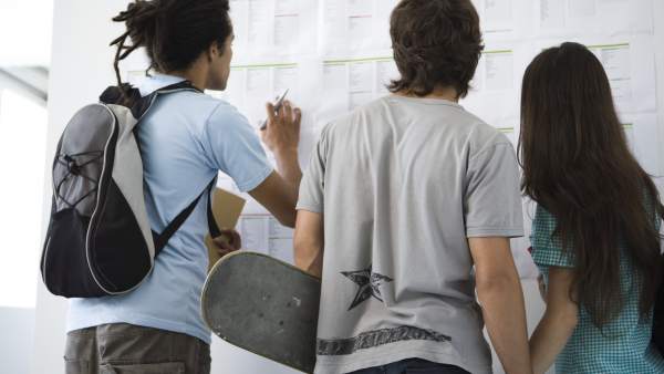 Estudiantes mirando un tablón de notas. Estudiantes mirando un tablón de notas.