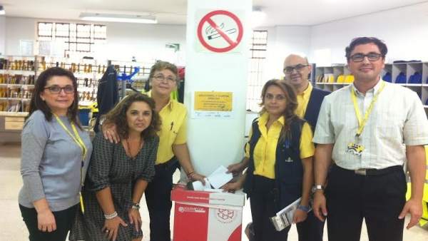 Miembros de Correos y Cáritas junto a una de las papeleras de reciclaje Miembros de Correos y Cáritas junto a una de las papeleras de reciclaje