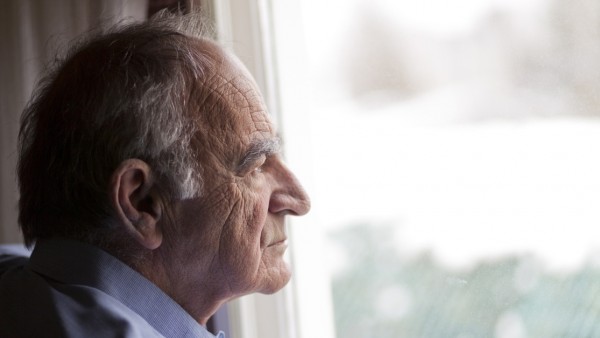 Una persona mayo mirando por la ventana. Una persona mayo mirando por la ventana.