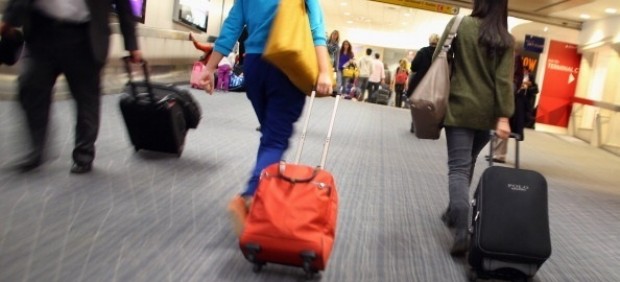 Pasajeros con maleta en aeropuerto 