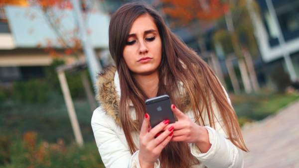 Una joven usando su teléfono móvil. Una joven usando su teléfono móvil.